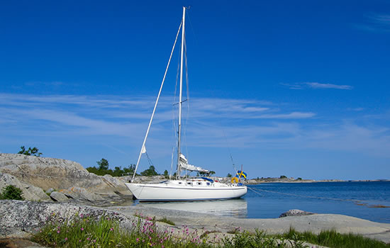 Sailboat moored at small rocky island in the outer part of the archipelago of Stockholm, Sweden