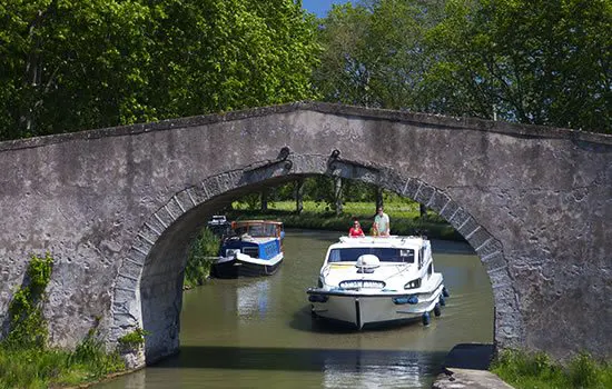 Hausboot auf dem Kanal vor einer Brücke