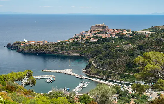 Segeltörn Toskana - Capraia mit Hafen und Elba im Hintergrund.